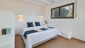 Une chambre à coucher avec un lit, deux lampes de chevet, une fenêtre et une table de chevet avec une lampe.