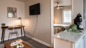 A modern room with a desk, chair, and a bed. There is a television mounted on the wall, a ceiling fan, and a window with blinds. - The Vulcan Octoplex - 8 Private Units/WiFi/Parking (Birmingham)
