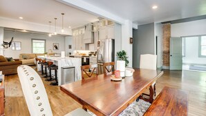 A spacious kitchen with modern appliances, a dining area with a wooden table, and a living room with a sofa and chairs. - 2 Mi to Dtwn: Stylish Urban Retreat in Birmingham (Birmingham)