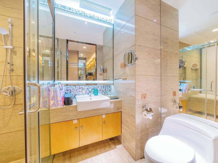 Une salle de bain moderne avec une douche à parois de verre, un lavabo blanc et des toilettes.