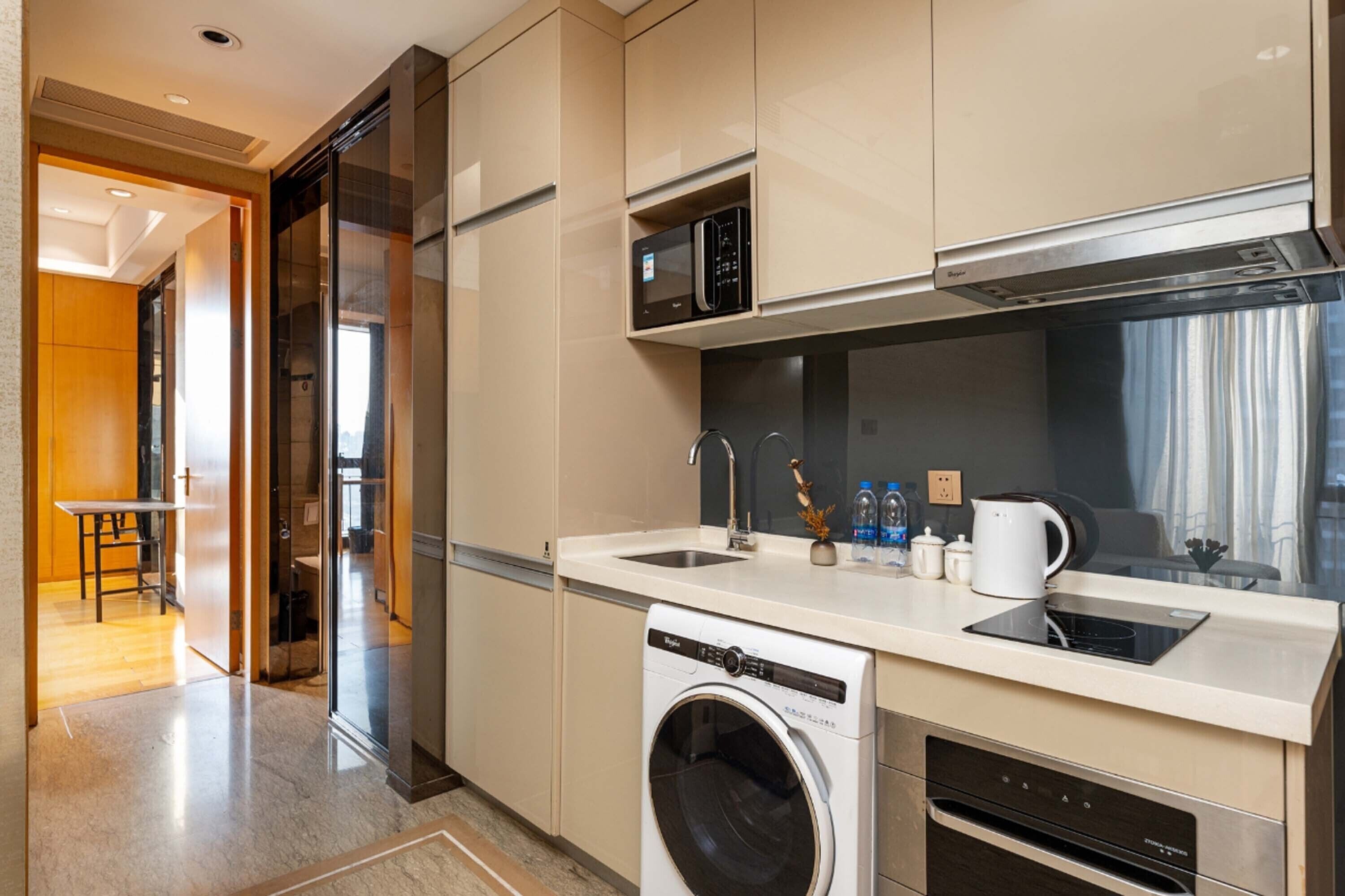 A modern kitchen with a built-in washer, microwave, and oven.