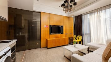 Una sala de estar moderna con un televisor de pantalla plana, armarios de madera, un sofá y una mesa de centro.