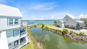 Une propriété située au bord de l’eau, comprenant une grande maison, un quai et un petit étang.
