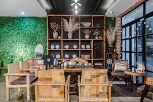 Una habitación acogedora con una pared verde, muebles de madera y varios objetos decorativos.