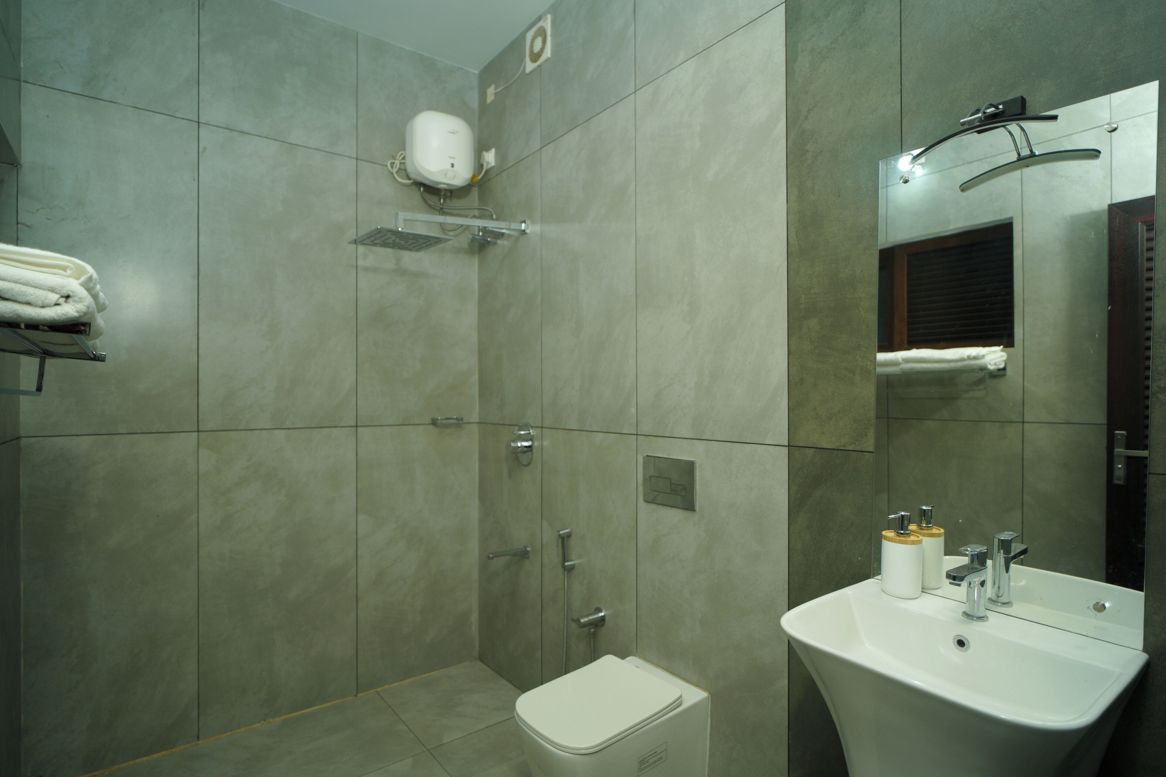 Een moderne badkamer met een douche, toilet en wastafel.