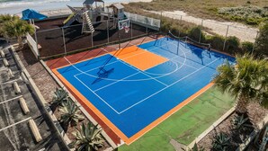 Una cancha de baloncesto con vista a la playa y al océano.