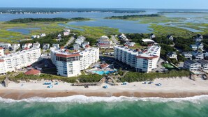 Un complejo turístico costero con varios edificios altos, una playa y un puerto deportivo.