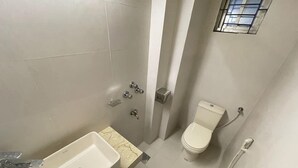 A bathroom with a sink, toilet, and shower. - The Asteria Hotel Bogura (Bogra)