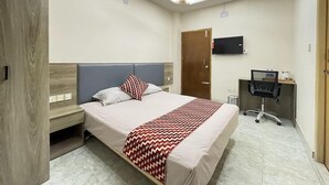 A bedroom with a bed, a desk, a chair, a television, and a ceiling fan. - The Asteria Hotel Bogura (Bogra)