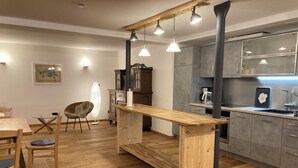 Une cuisine moderne avec des plans de travail en bois, un îlot central et des luminaires suspendus.