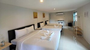 A hotel room with three beds, a desk, a chair, a ladder, and an air conditioning unit. - Monkey House Hostel Koh Samui (Koh Samui)