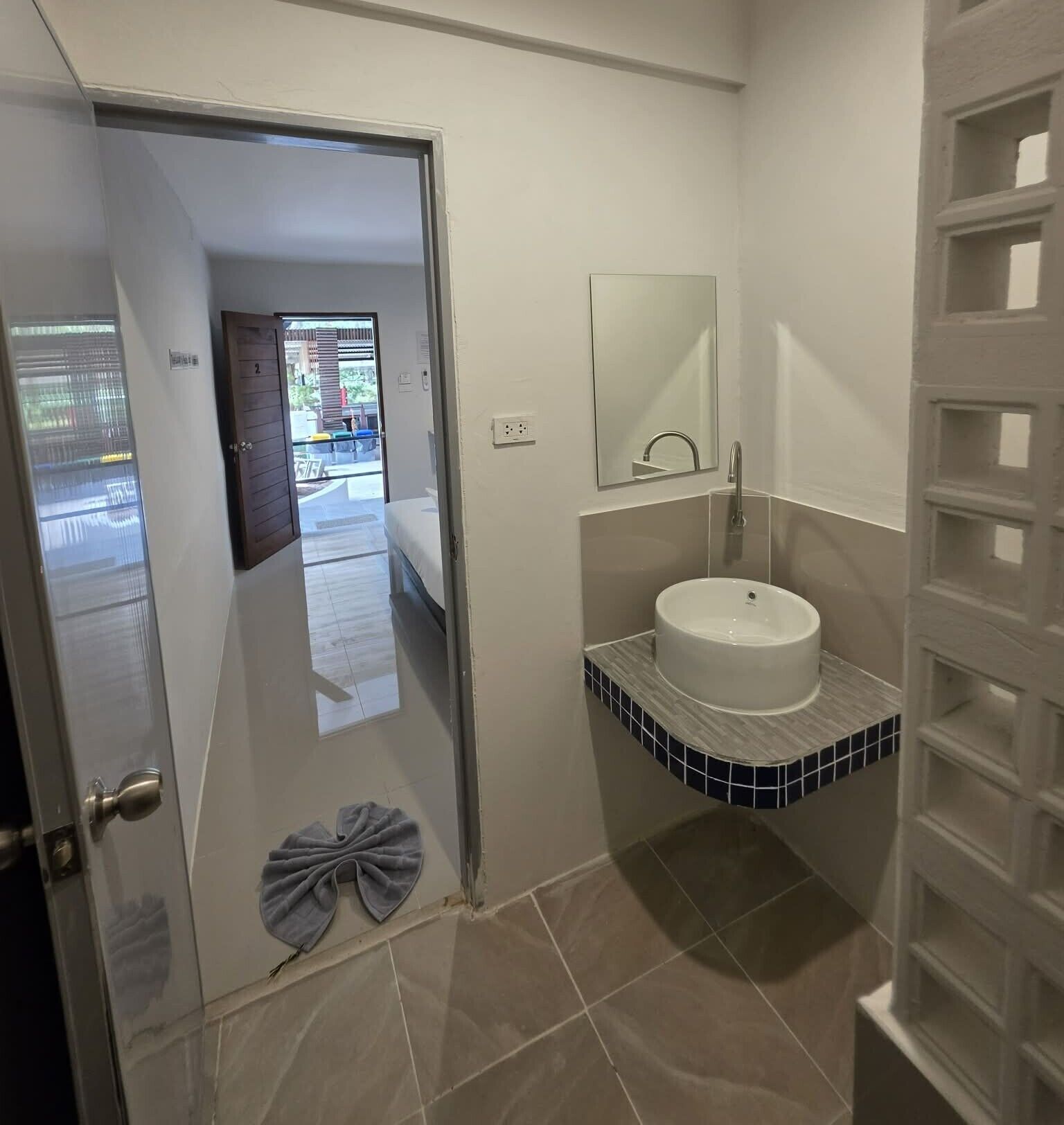 A bathroom with a white sink, a mirror, and a towel rack.