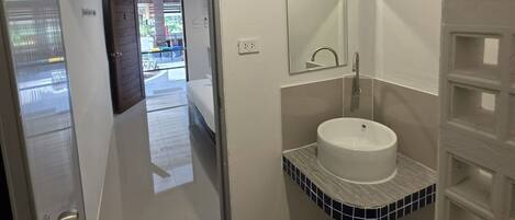A bathroom with a white sink, a mirror, and a towel rack.