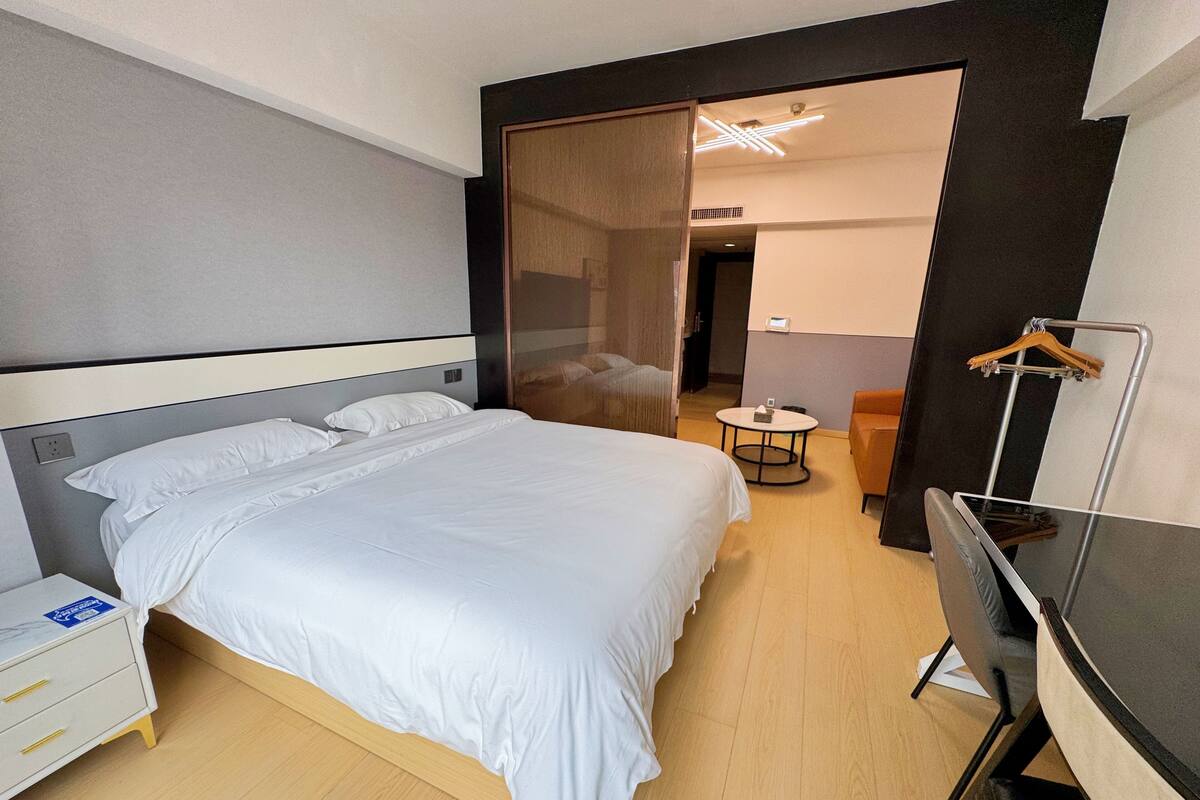 Une chambre d’hôtel moderne avec un grand lit, un bureau et une petite table.