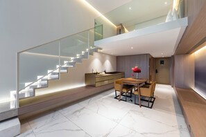 Ein modernes Interieur mit Treppe, Essbereich und Küche.