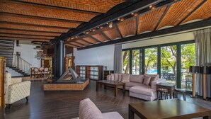 A spacious living area with a fireplace, comfortable seating, and large windows offering a view of the outdoors. - Cottage House - Adult Only (Kemer)
