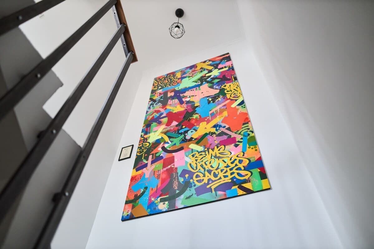 A staircase with a handrail and a wall-mounted artwork.