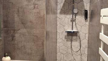 Un baño moderno con ducha, lavabo e inodoro.