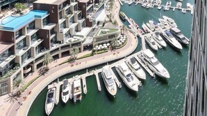 A marina with boats docked, surrounded by high-rise buildings.