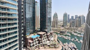 A high-rise hotel with multiple floors, a rooftop pool, and a marina with boats.