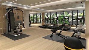 Ett modernt gym med träningsutrustning, stora fönster och ett trägolv.