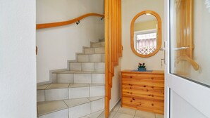 Eine Treppe mit Holzhandläufen, eine Kommode mit Schubladen und ein Spiegel mit Holzrahmen.