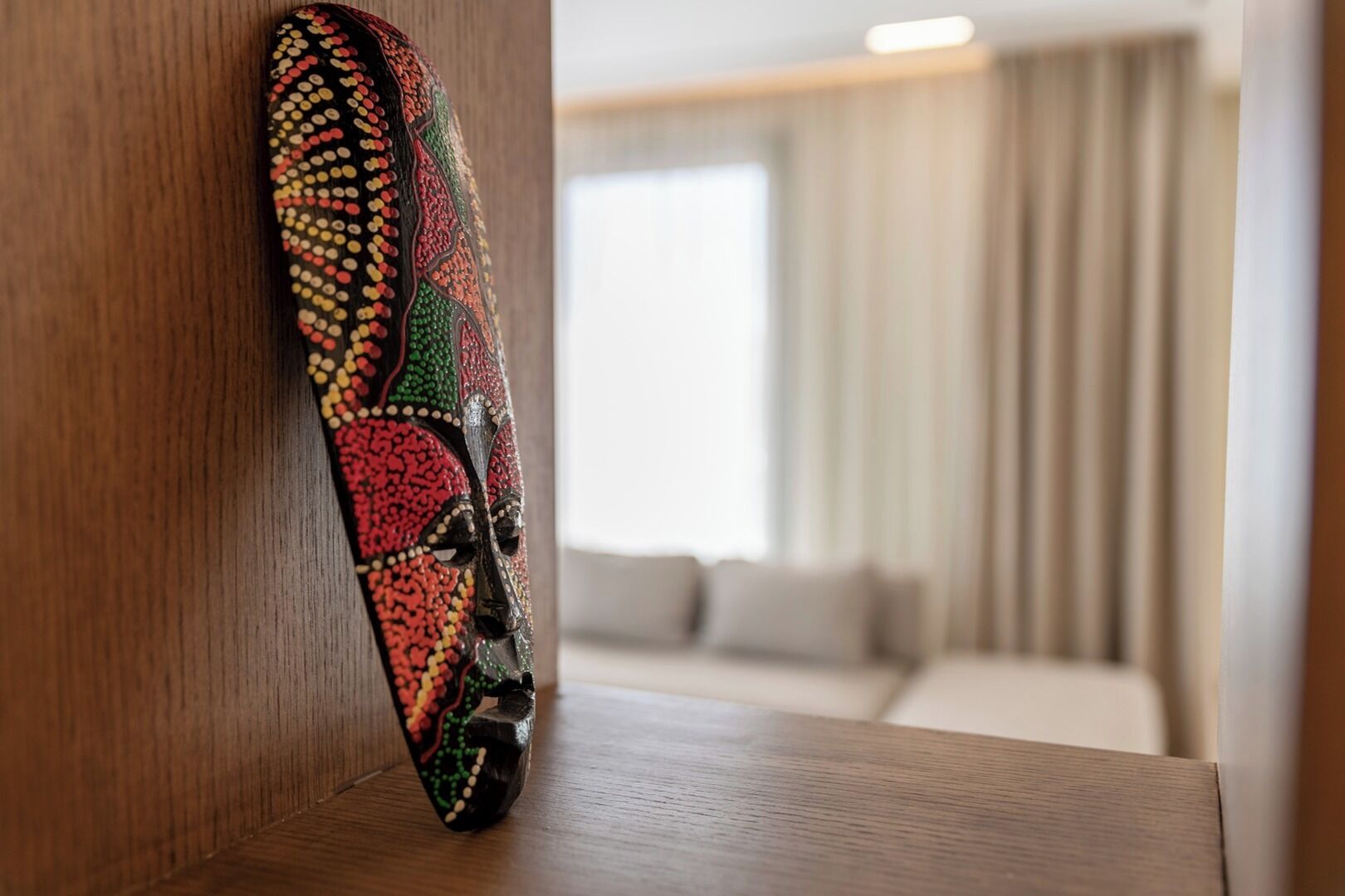 A wooden wall with a colorful, patterned artwork.