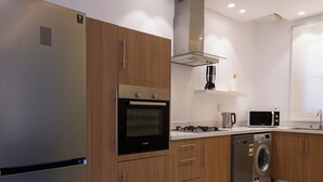 Una cocina moderna con electrodomésticos de acero inoxidable, armarios de madera y lavavajillas integrado.