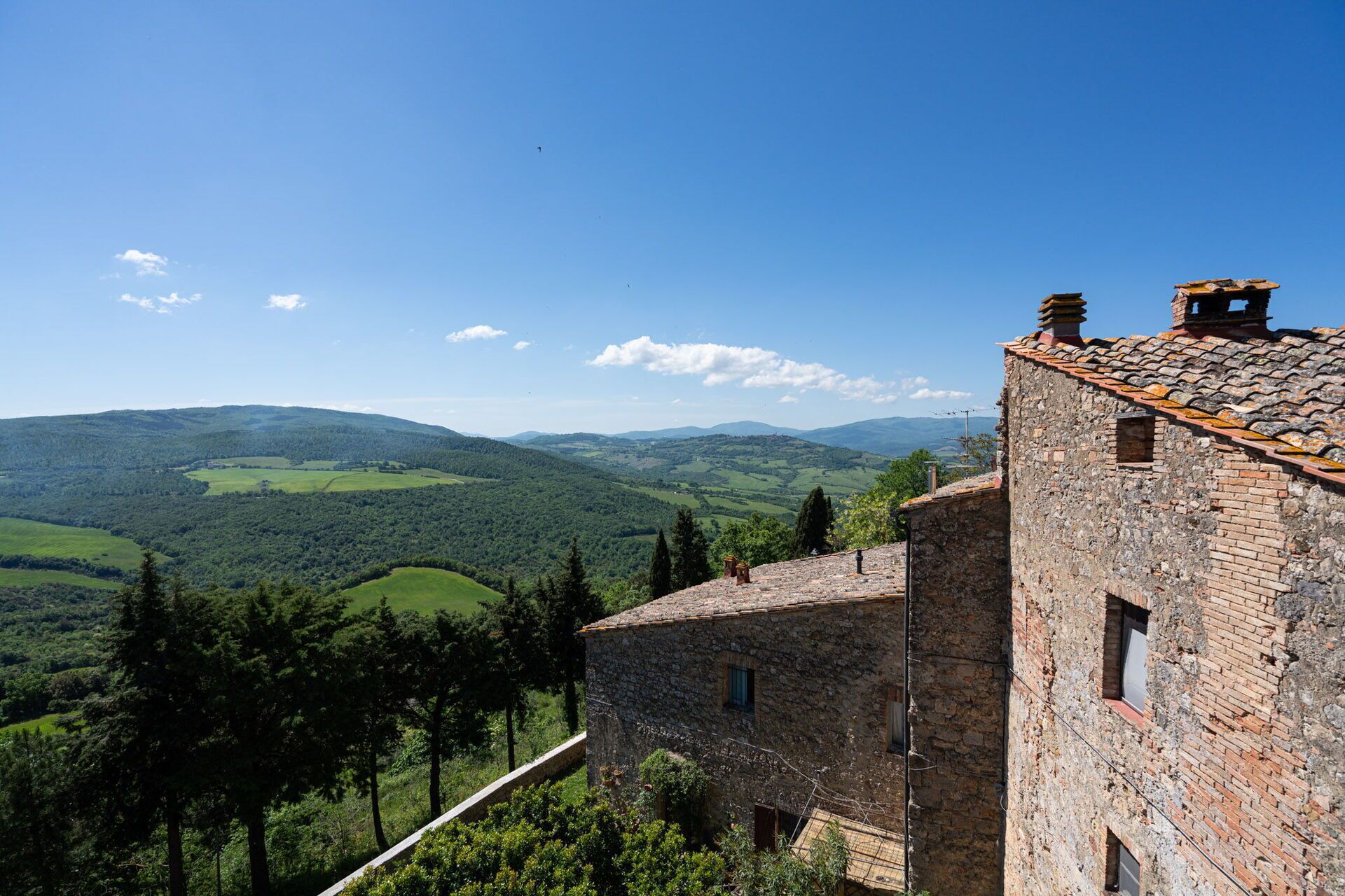 A stone building with a view of rolling hills and a clear sky.