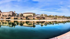 A waterfront hotel with a pool reflecting palm trees and buildings. - Wohnung Nr. 4 (Mühlheim am Main)