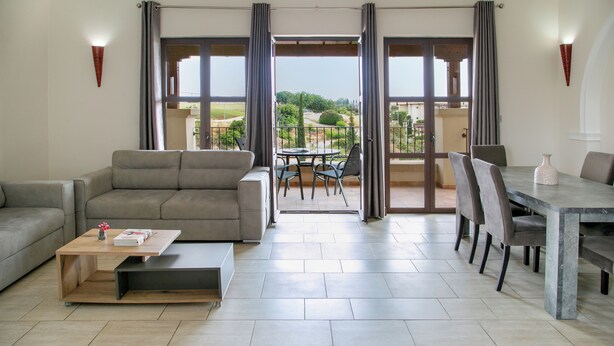 Un salon moderne comprenant un canapé, une table basse et un coin repas avec des chaises et une table.