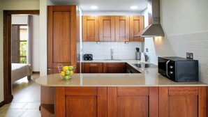 Une cuisine compacte avec des meubles en bois, un four à micro-ondes encastré et un petit évier.