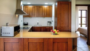 A kitchen with wooden cabinets, a microwave, a coffee maker, and a fruit bowl on the counter. - 2 Bedroom Apartment - AHB11 (KOUKLIA)