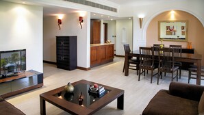 A modern living room with a flat-screen TV, a glass-top coffee table, and a dining area with wooden furniture. - 2 Bedroom Apartment - AHB11 (KOUKLIA)
