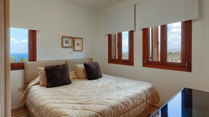 Een slaapkamer met een bed, een televisie en uitzicht op de omgeving.