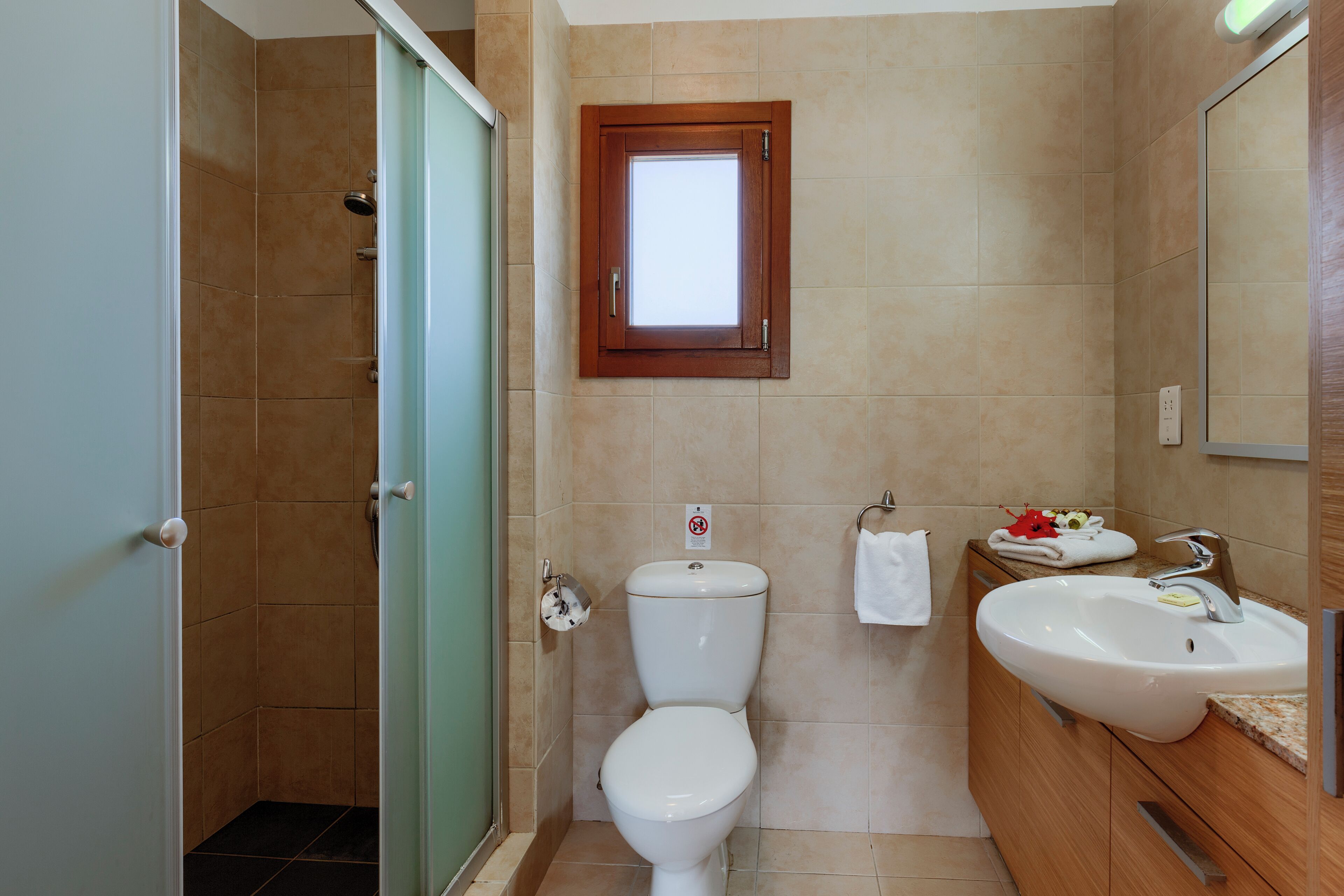 A bathroom with a toilet, sink, and shower.