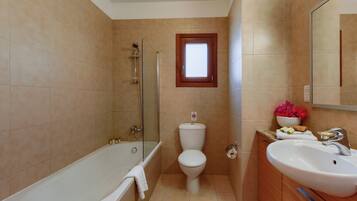 Ein Badezimmer mit einer Badewanne, Toilette und Waschbecken.