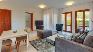 A modern living room with a white table, grey sofa, and a blue armchair. - 2 Bedroom Apartment - CB02 (kouklia)