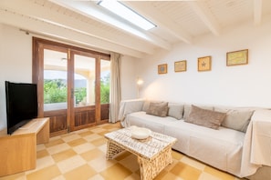 Una sala de estar con sofá, televisor y piso de piso a cuadros.