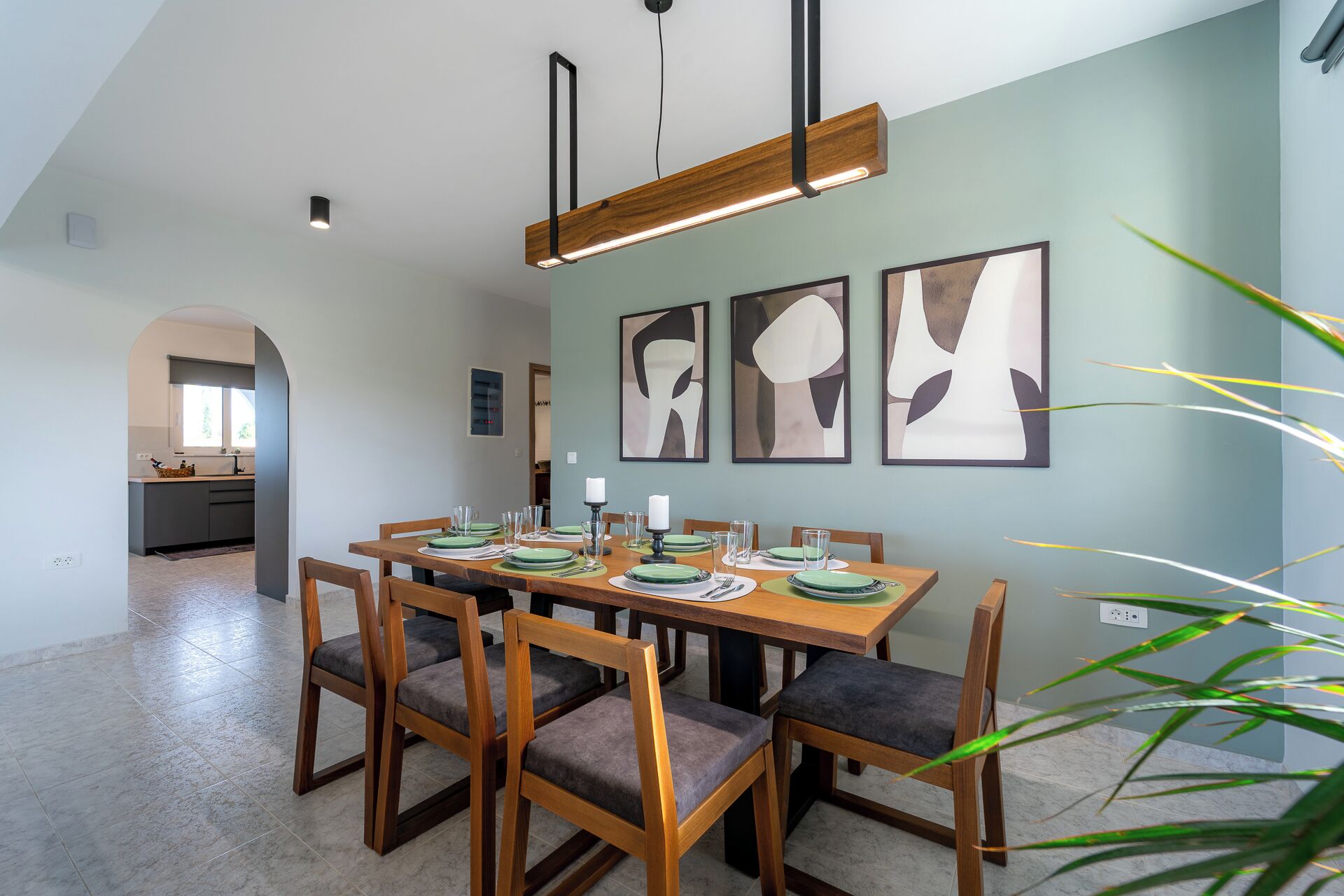 A dining area with a wooden table set for four, surrounded by chairs with cushioned seats.