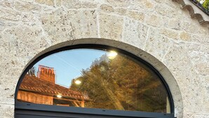 A stone building with a large arched window. Inside, there is a table and chairs. - Domaine de Péroline: Swimming pool and Jacuzzi (Cézac)