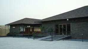 A building with a stone facade, a covered entrance, and a staircase leading to the entrance.