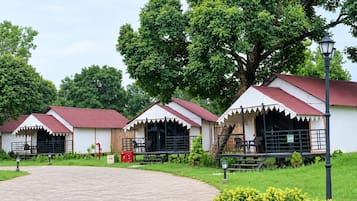 A row of white cottages with red roofs, each with a balcony and a fire extinguisher nearby.