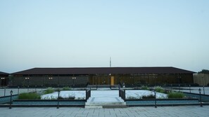 A building with a flat roof, large windows, and a central entrance with steps. - Evoke Rambagh Ayodhya (Faizabad)
