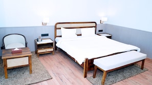 Ein Schlafzimmer mit einem Bett, Nachttischen, einem Sessel und einem Schreibtisch.