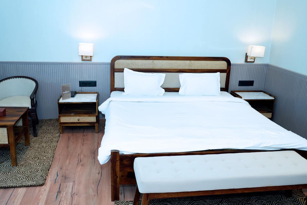 A hotel room with a bed, bedside tables, a chair, a bedside lamp, and a rug.