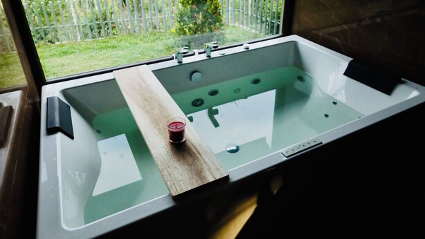 Ein Badezimmer mit Badewanne, Waschbecken und einem Fenster.