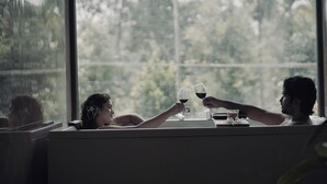 Ein Zimmer mit großem Fenster, einer Couch und einem Tisch mit Glas und Tasse.