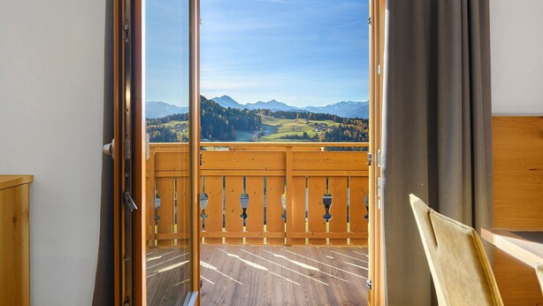 A room with a wooden floor, a wooden door, and a view of a mountainous landscape. - Apartment 'Ifinger' with Mountain View, Shared Garden and Wi-Fi (Avelengo)