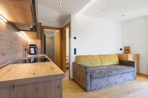 Una cocina moderna con armarios de madera, una cafetera espresso integrada y una encimera de madera.